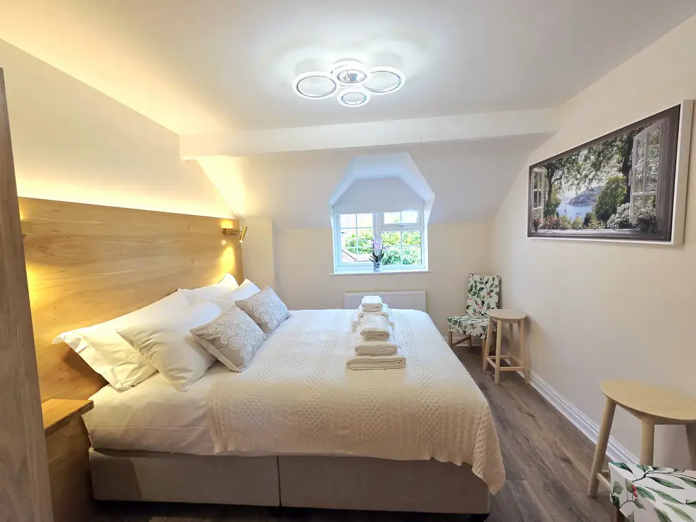 The main bedroom, showing the bed, dormer window and chair